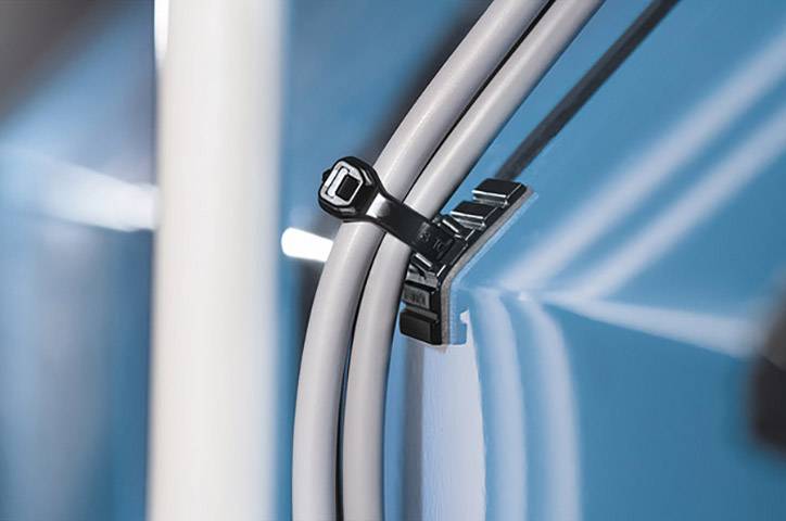 A cable tie secures black cables to a blue surface.