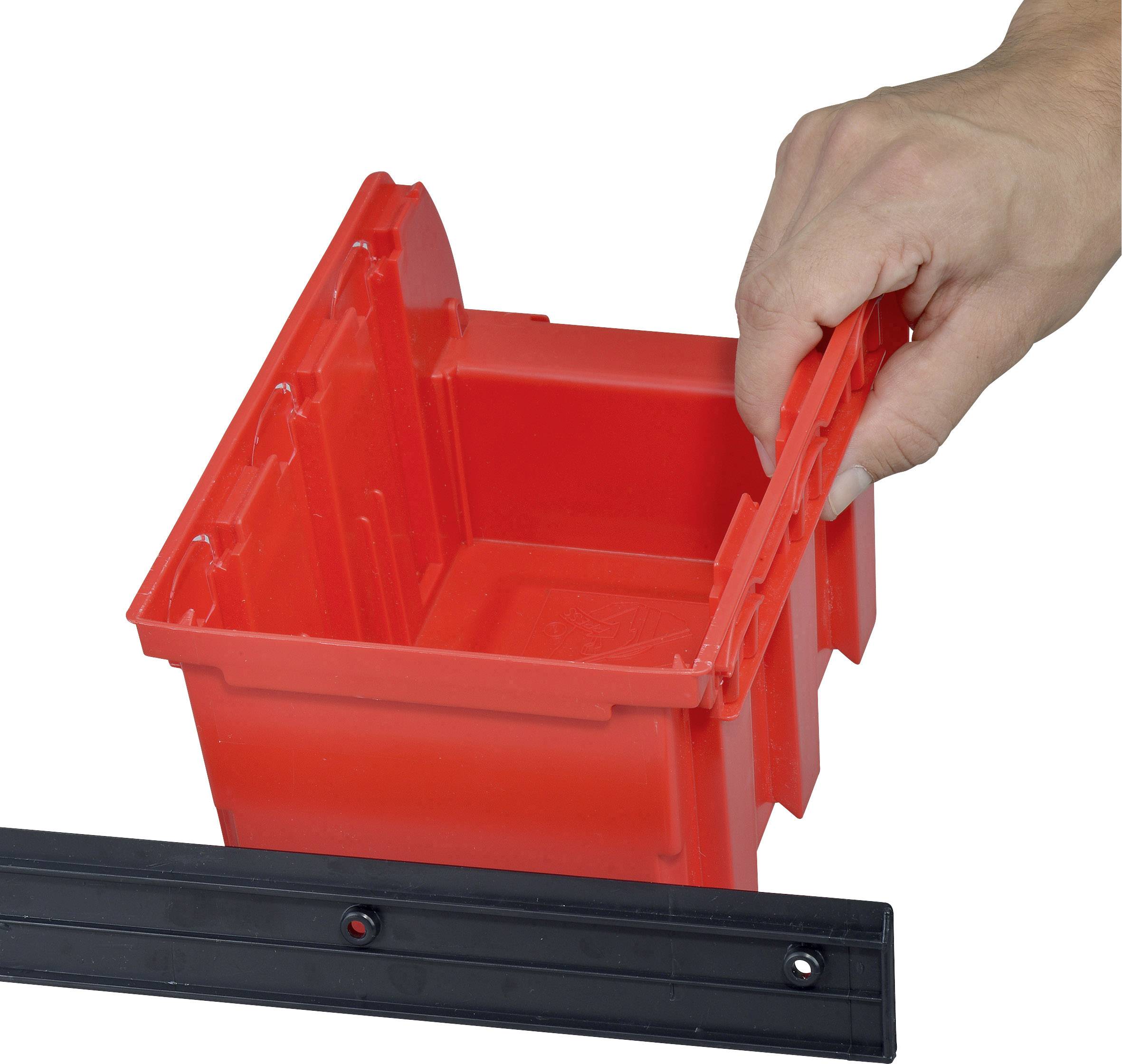 A hand is stacking a red plastic container on a black shelf.