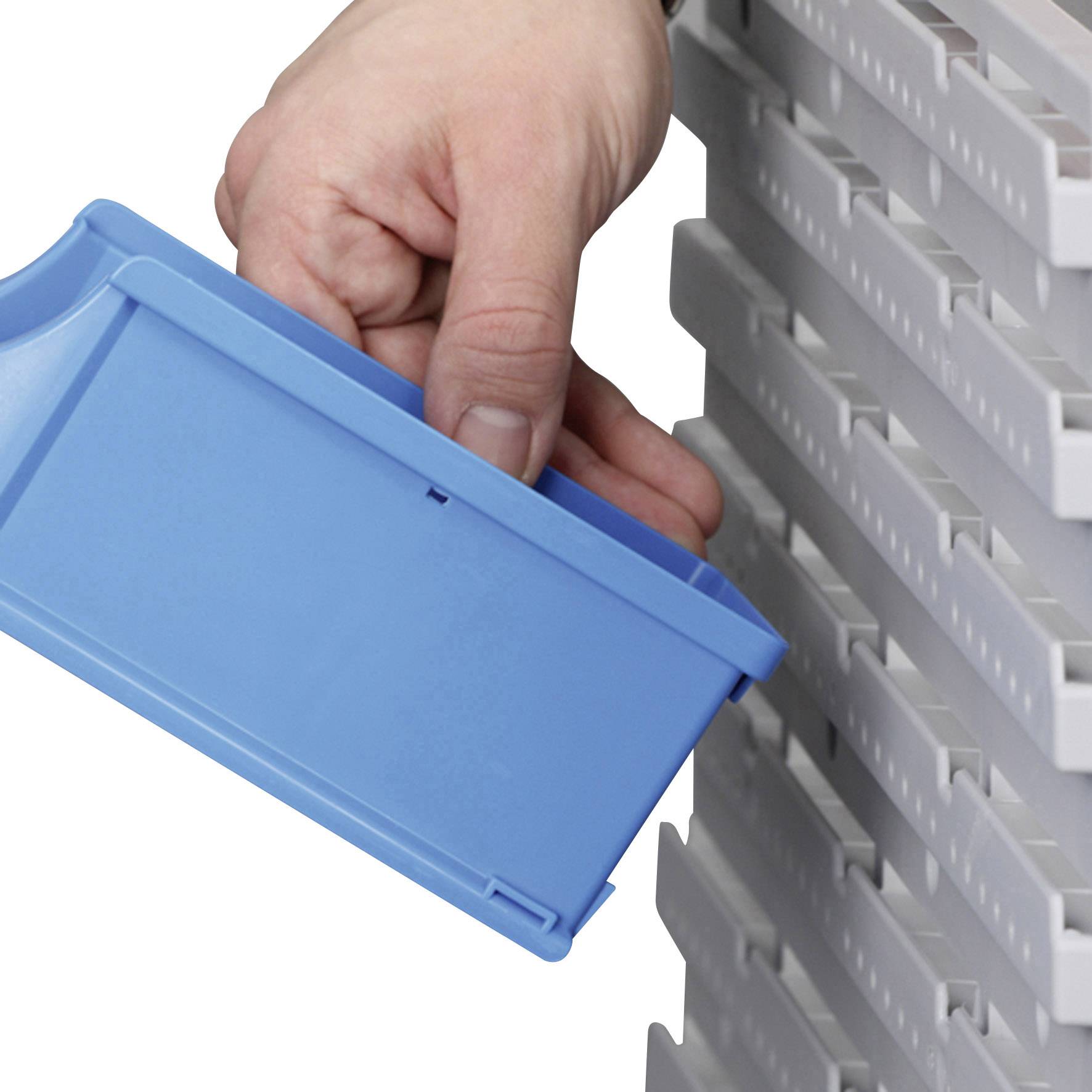 A hand pulls a blue plastic box from a white shelf.