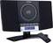 A compact stereo system with a CD player and digital display. A remote control is placed in front of it. Time on display: '12:08'.