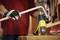 A person is bending a pipe using a yellow hot air blower in a workshop.