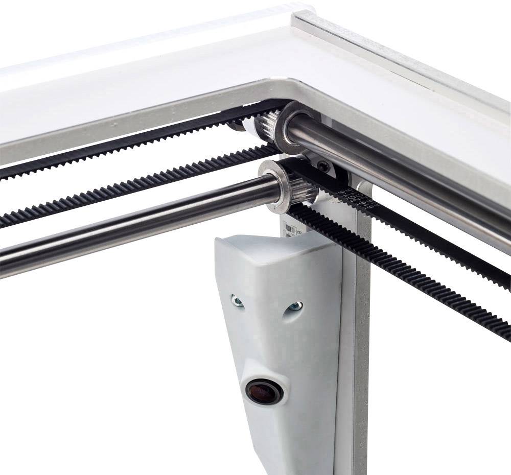 A mechanical system with belt drive shows gears, belts and a white support structure, possibly for a 3D printing device.