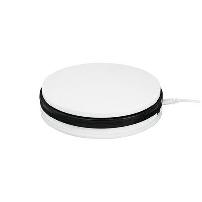 A flat, round, white electrical device with a black edge and power cable. Possibly a hob or heating appliance.