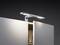 A modern LED light is mounted on a half-open cupboard and illuminates the contents.