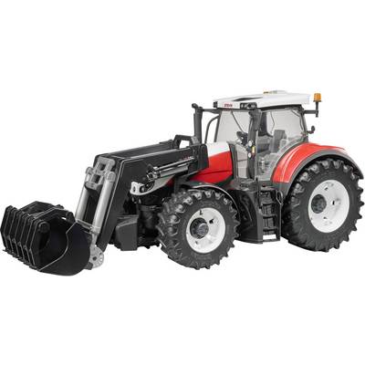 A red toy tractor with a large bucket and black tyres. Sits on a flat surface, side view showing details.