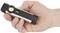 A hand is holding a small, black torch with a visible button and LED light at the front.<br><br>Note: In British English, "torch" is used instead of "flashlight", which is more common in American English.