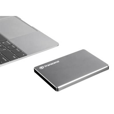 External hard drive next to a laptop, both in silver finish. The hard drive is slim and compact, brand name 'Transcend'.