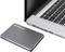 External hard drive next to an open laptop on a desk. The laptop is partially visible.