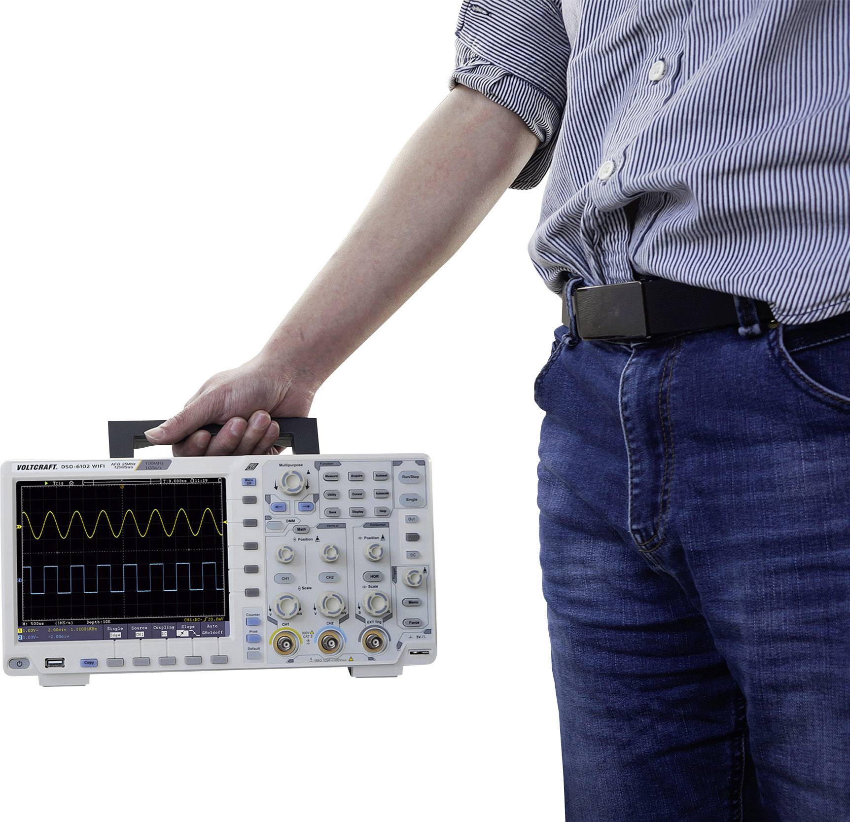 A person is holding an oscilloscope that displays a sinusoidal wave pattern on the screen.