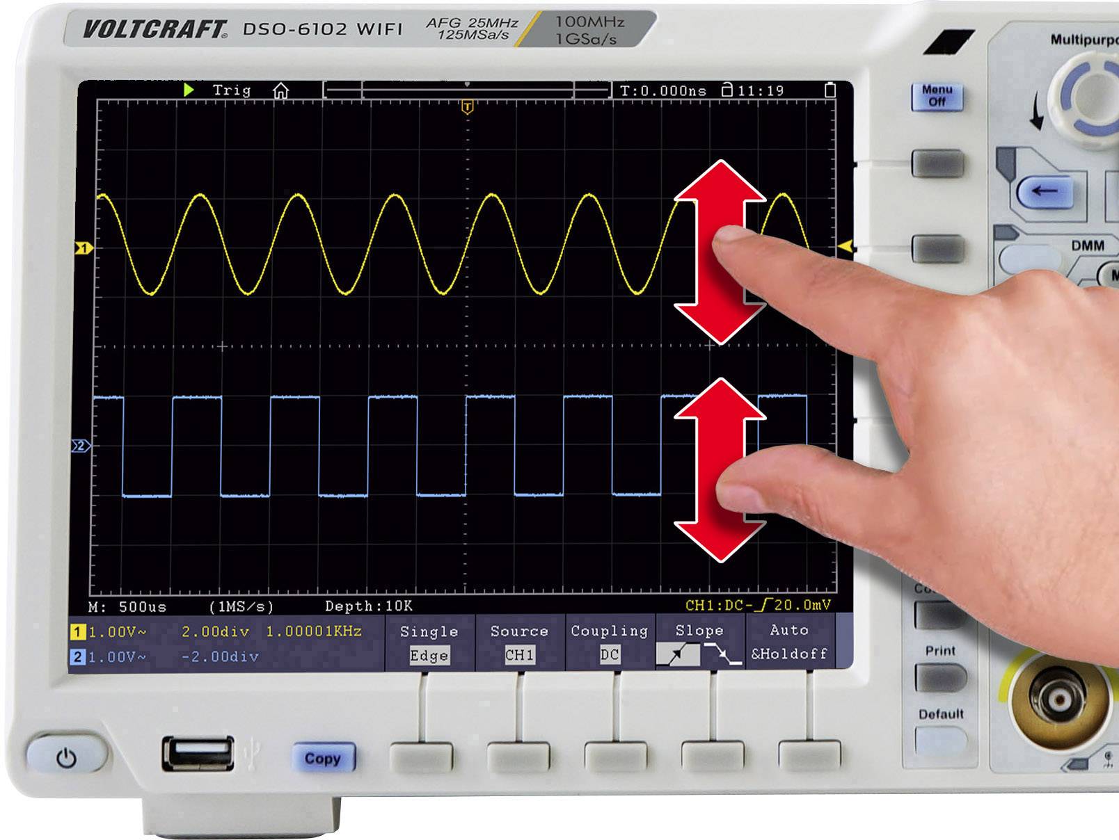 A oscilloscope shows two waveforms. A hand points to a section of the waves to mark differences in height or amplitude.