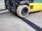A forklift is driving over a rubber cable ramp, protecting cables on the ground.