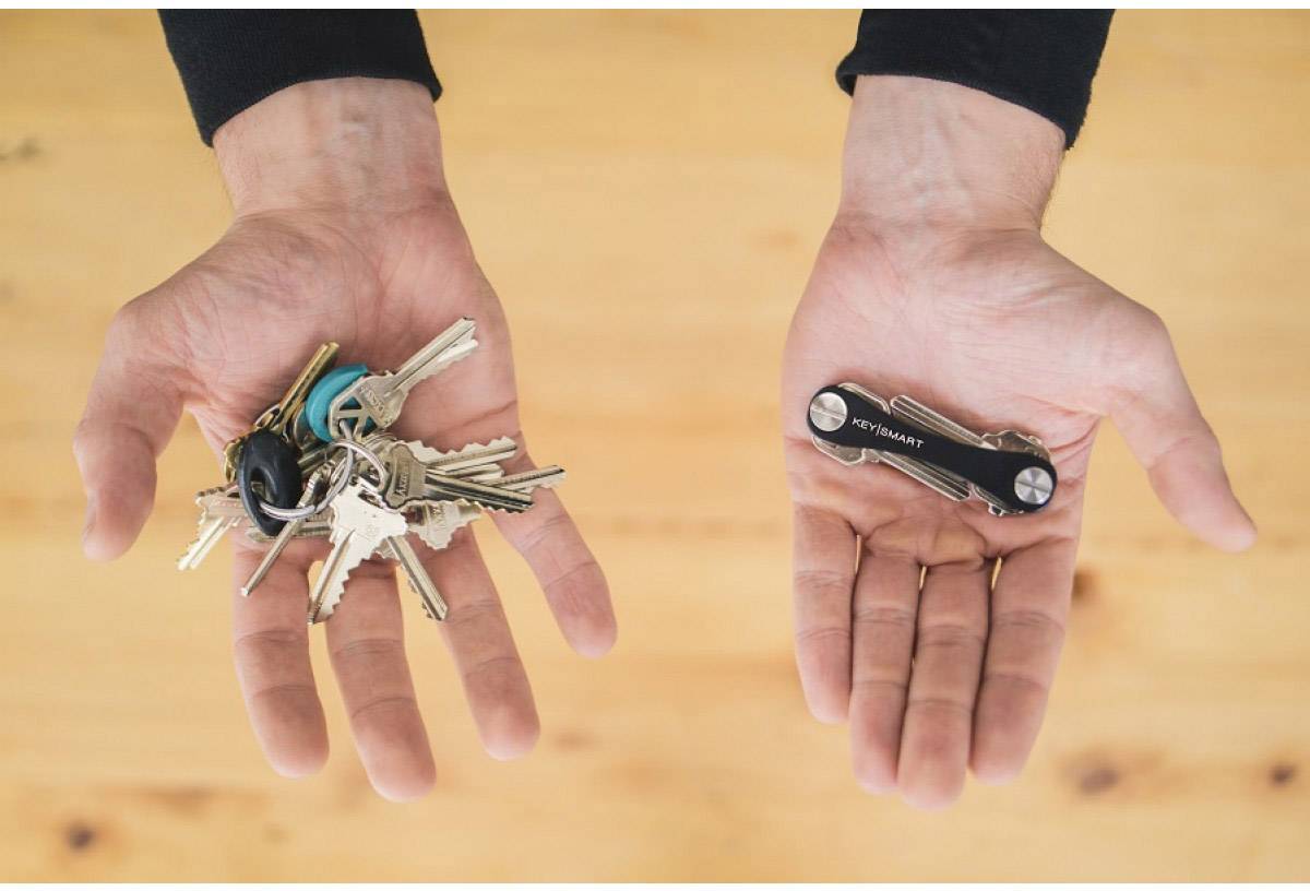 One hand holds multiple keys, while the other holds a compact key organiser that takes up less space.