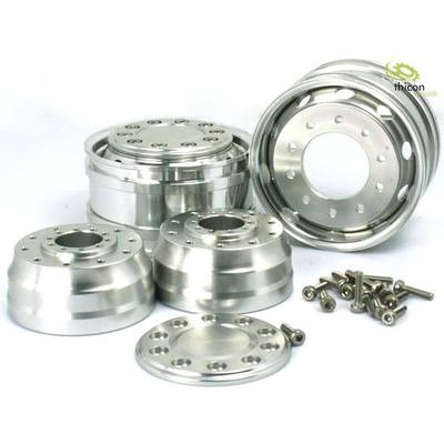 Various polished metal wheels and bolts, arranged on a white surface, offer a selection of automotive parts.