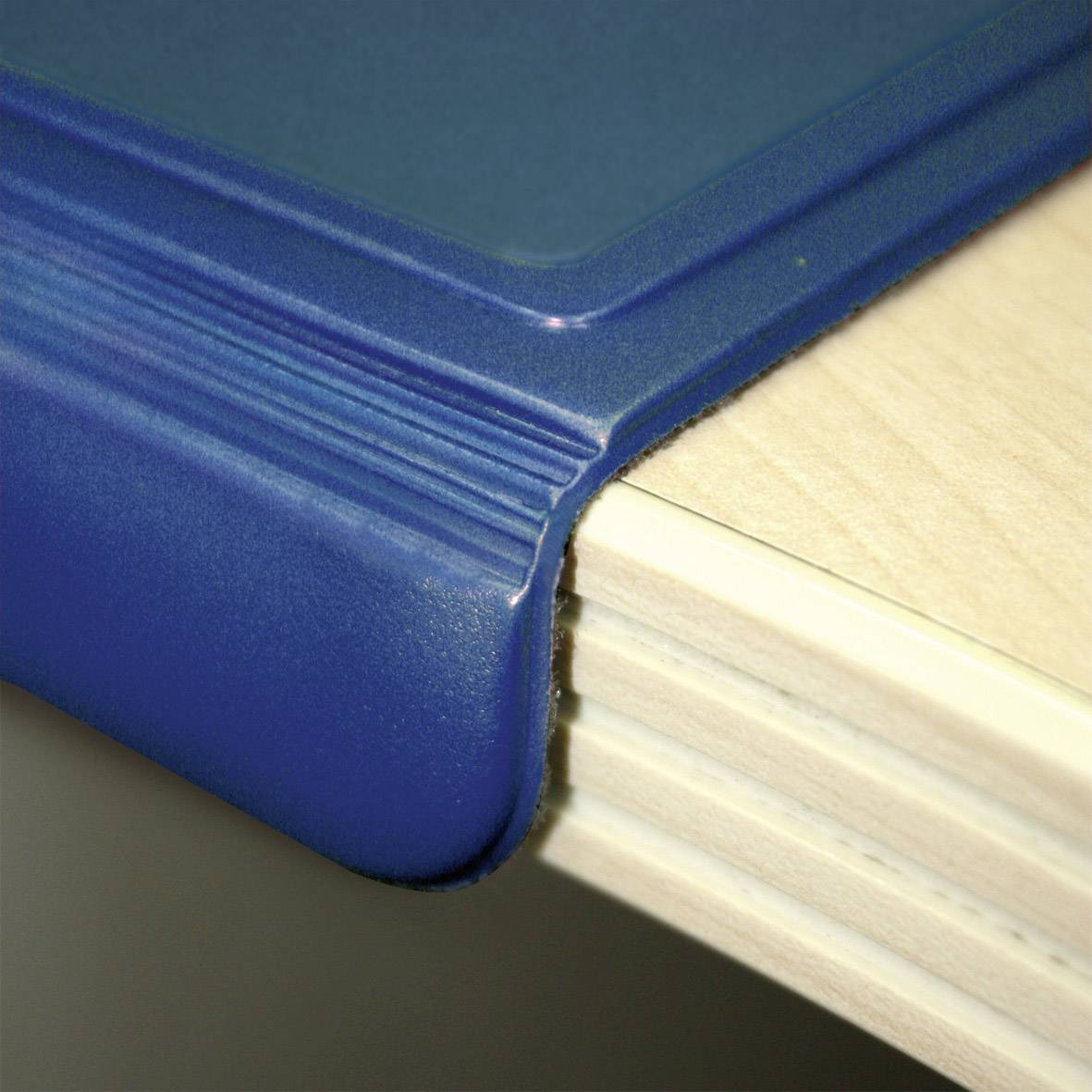 Blue edge protection on a table edge to prevent injuries and wear.