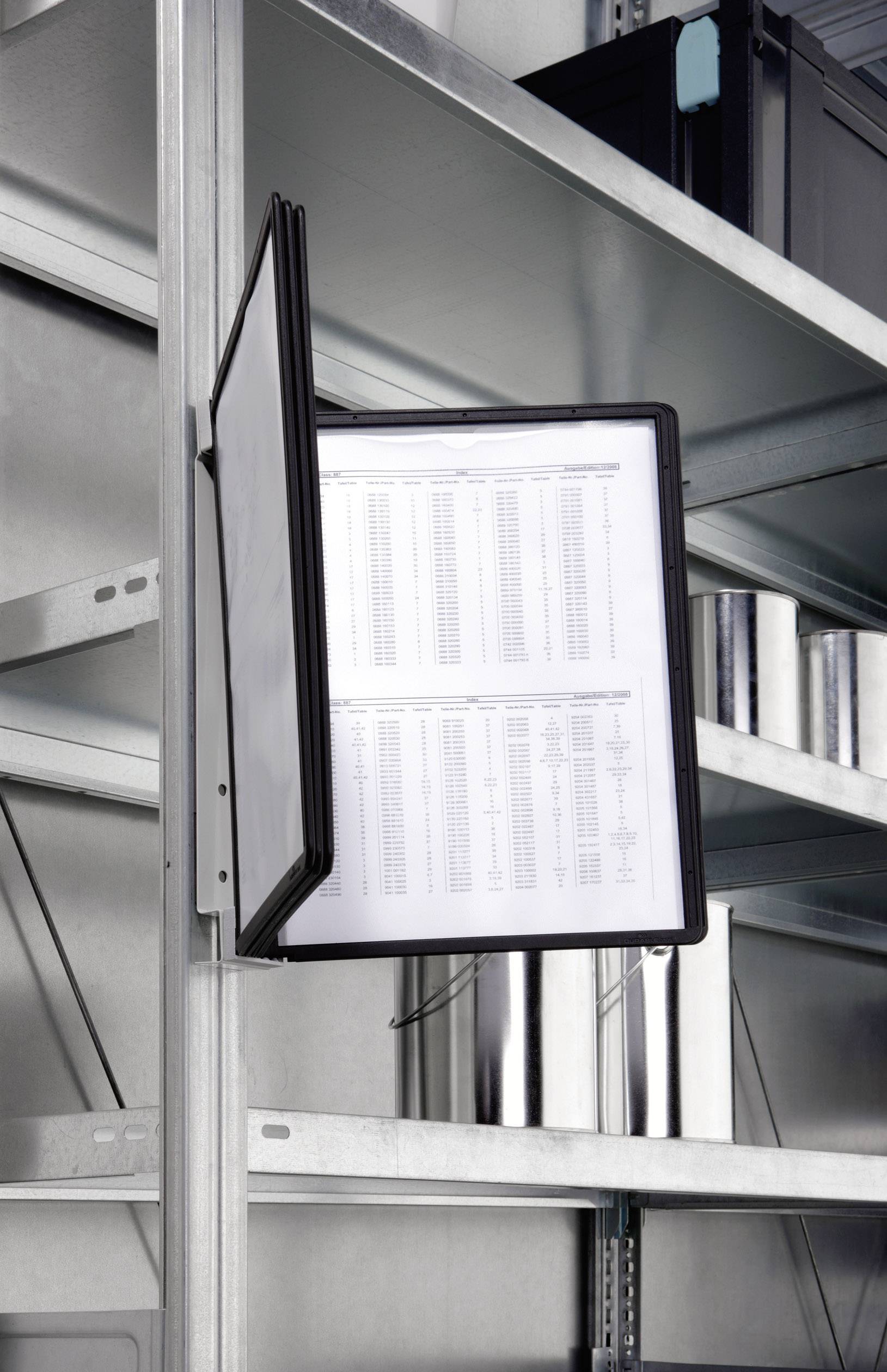 An open ring binder is hanging on a shelf, displaying a table with data and figures. Metal shelving is visible in the background.