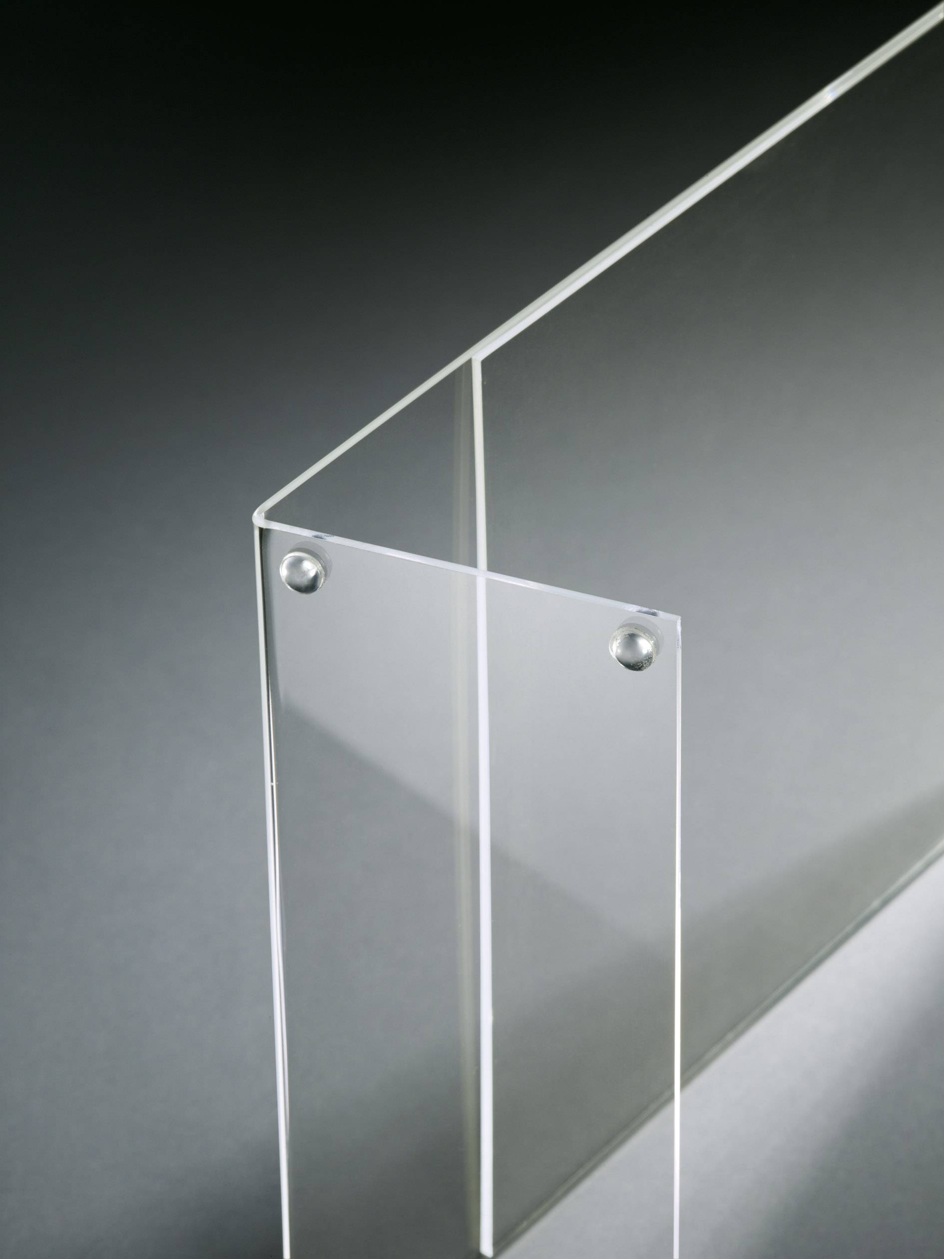 Two transparent, perpendicularly connected acrylic panels against a grey background, demonstrating modern design and minimalism.