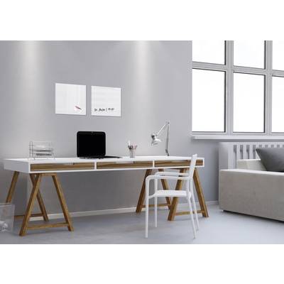 Modern desk with a laptop, lamp, and chair, with a sofa beside it. Bright walls and large windows allow plenty of daylight to enter.