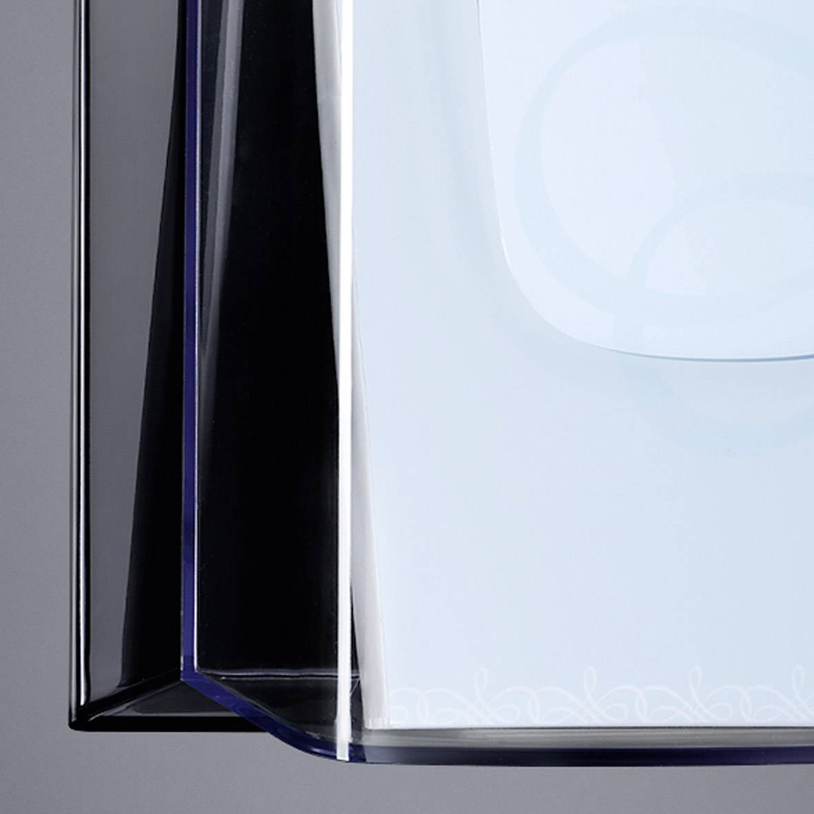 A transparent and blue geometric artwork hovers in front of a grey background.