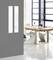 Modern meeting room, wooden table with white chairs. Large windows provide plenty of natural daylight. Minimalist design in the background.
