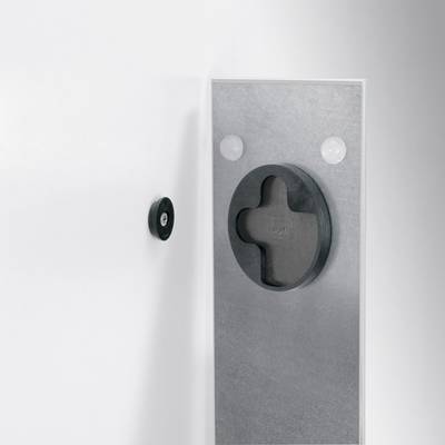 A round black handle and a rectangular control panel with crosses and round buttons on a white wall.