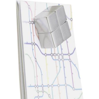 A silver cube resting on a notebook with a colourful grid pattern reminiscent of underground railway maps.