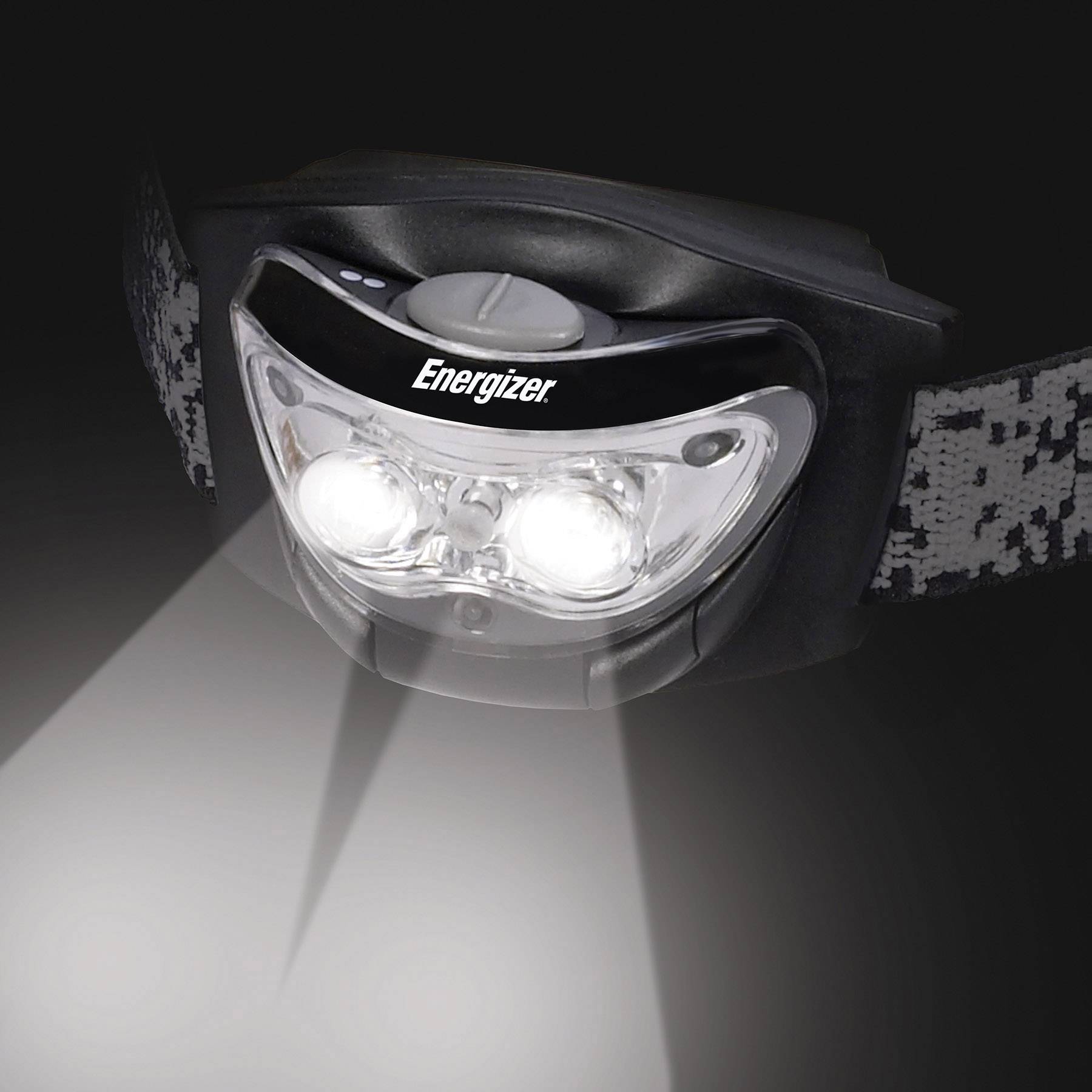 'Close-up of a black head torch with two illuminated LEDs. Brand: Energizer. Background dark.'