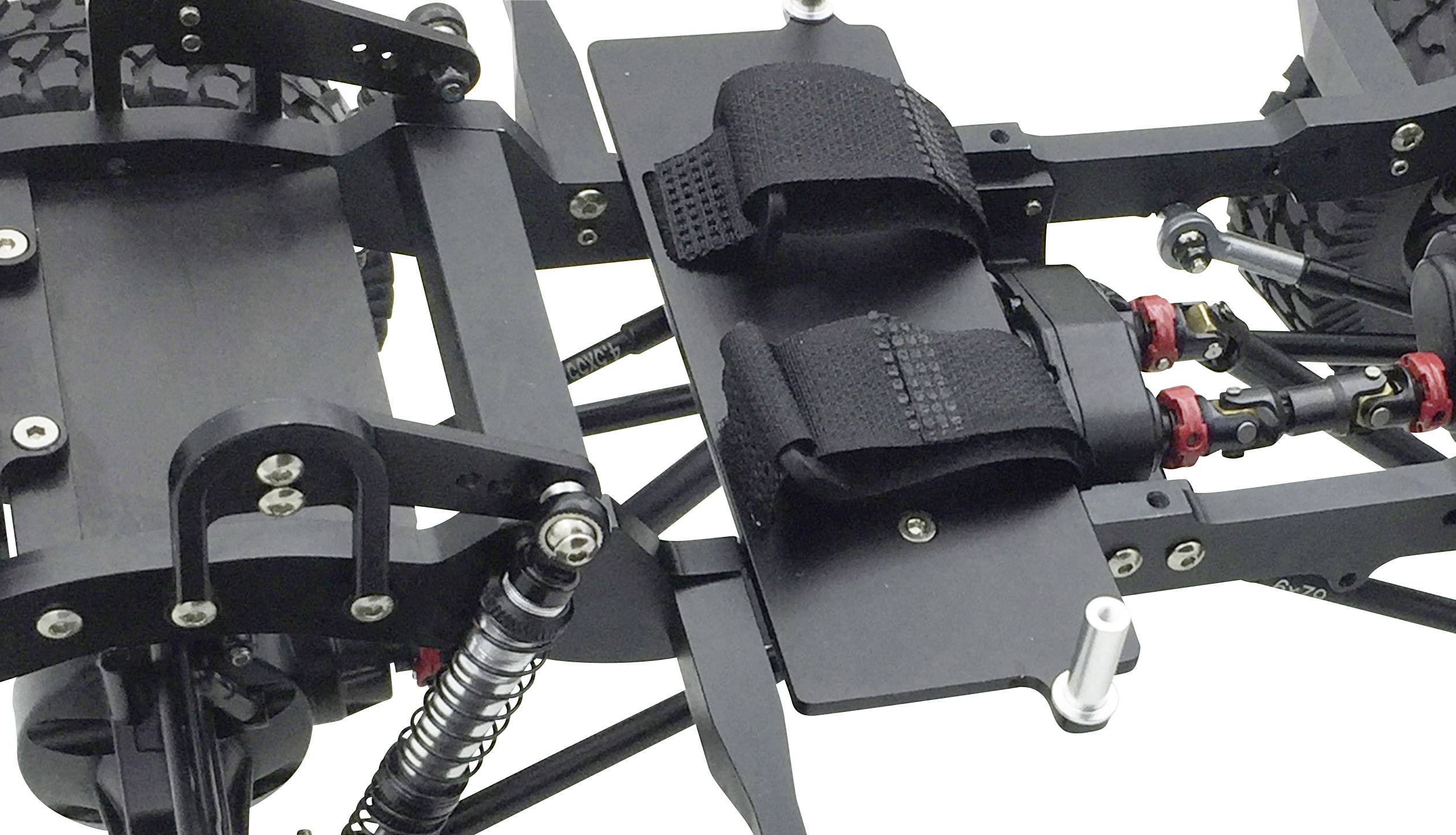 Close-up of part of a model vehicle with black straps and springs, showing the suspension and structure.