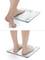A person steps onto a digital scale and the display shows their weight. The scale has a glass surface.