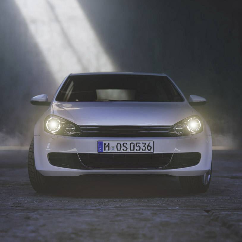 A white car is parked in a dark room with its headlights on, facing the camera head-on. A beam of light comes from above.