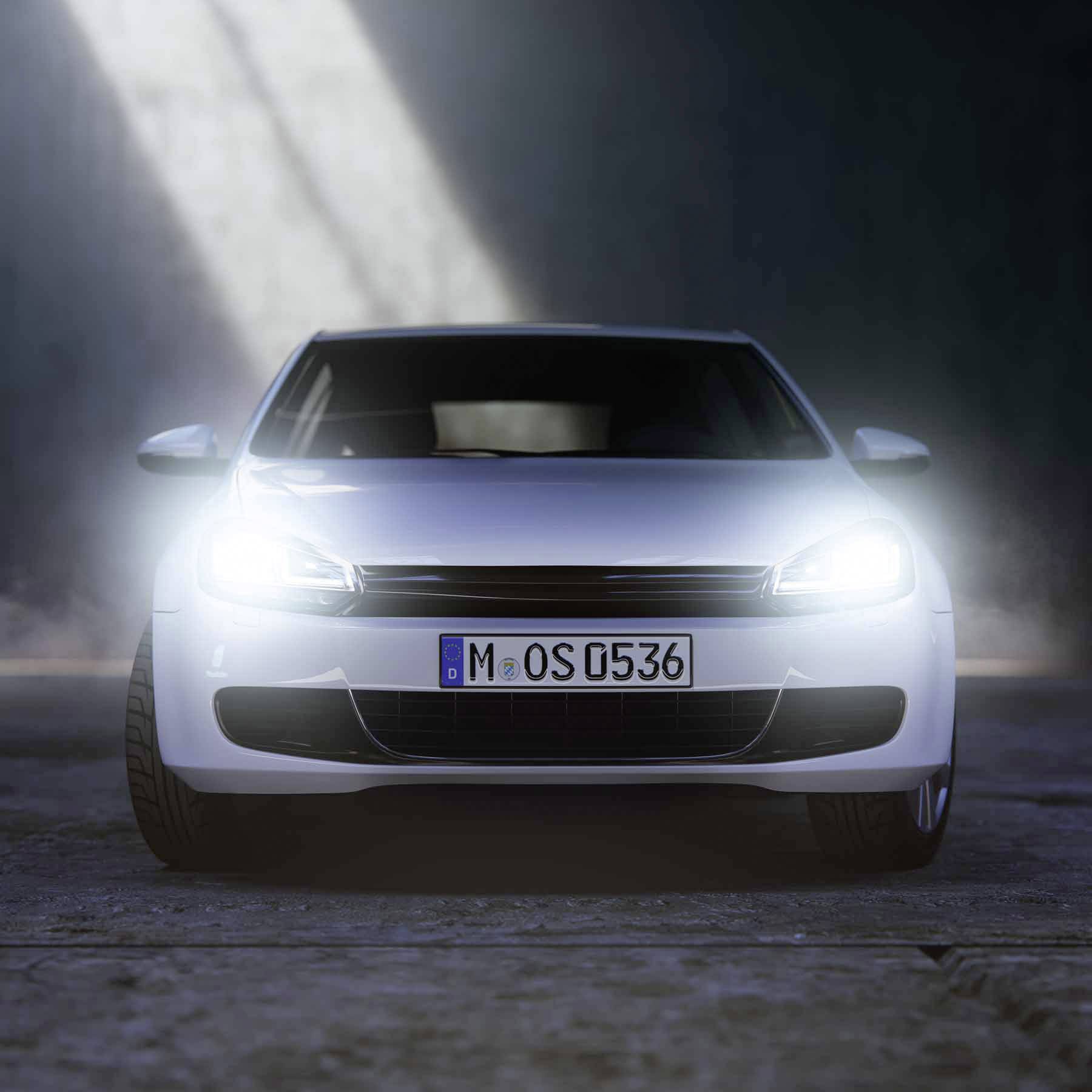 A white car with its headlights illuminating a dark room, visible from the front. Number plate: 'M-OS 0536'.