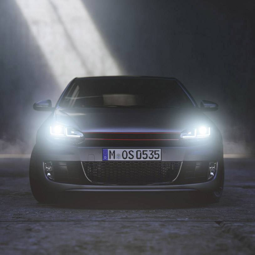 A car with headlights switched on is standing on a foggy road. The front view shows the number plate and the radiator grille.