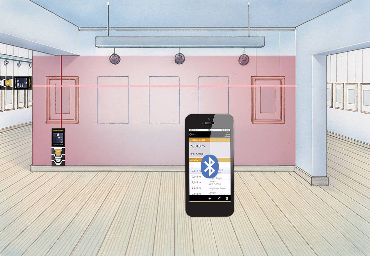 A smartphone displays an app for room measurement via Bluetooth, in a room with empty frames on pink walls.