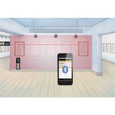 A smartphone displays an app for room measurement via Bluetooth, in a room with empty frames on pink walls.