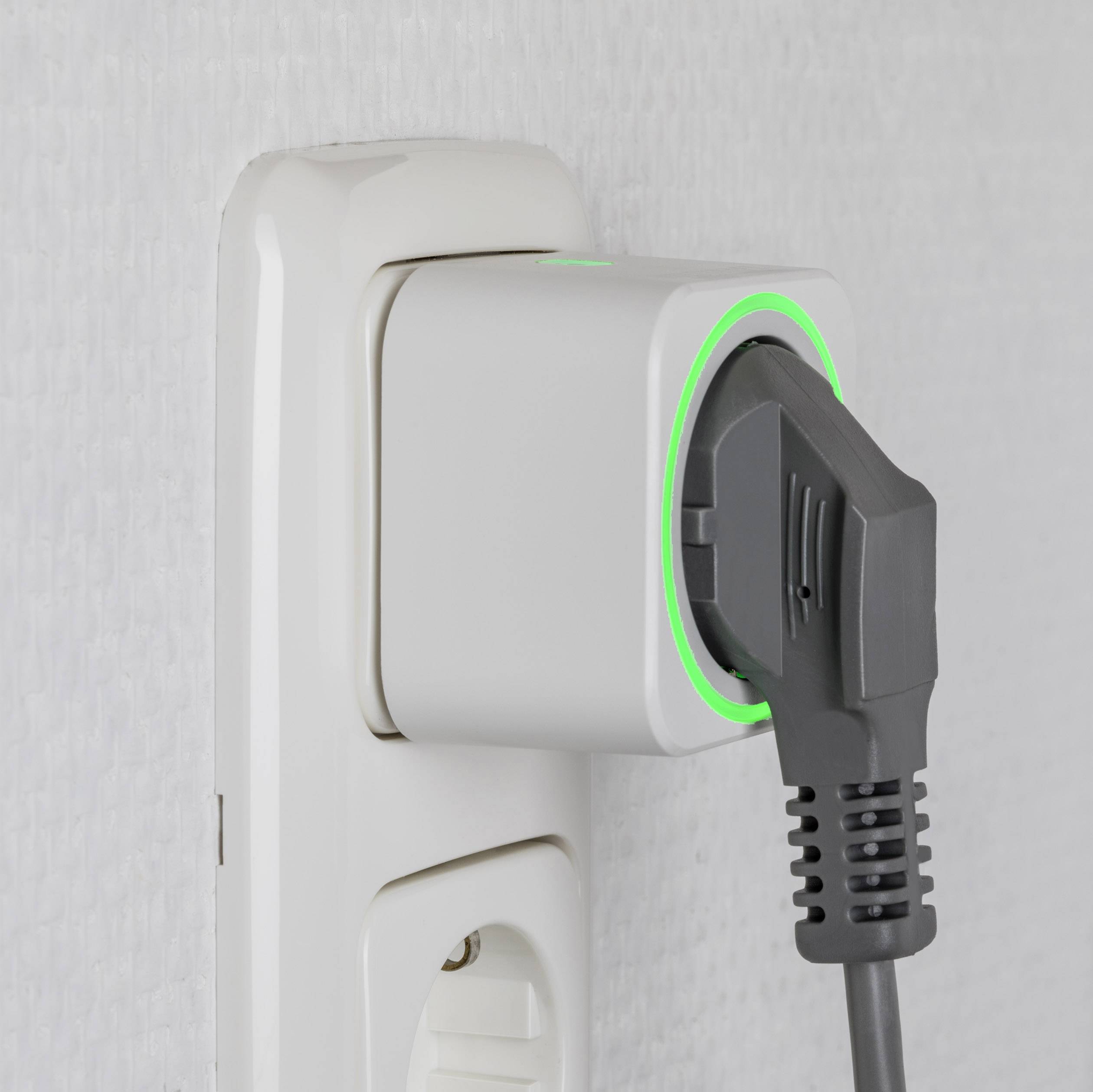 A black plug is inserted into a white socket, with a green illuminated ring around the plug indicating the charging process.