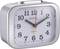 A silver alarm clock shows 11:05. It has a white dial with black numbers and colourful hands.