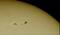The image depicts the solar surface with a group of sunspots. These dark spots are cooler than the surrounding areas.