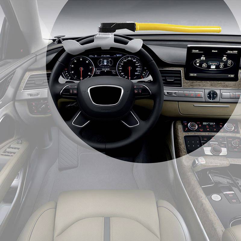 Interior of a modern car with a steering wheel, advanced dashboard, and monitor. A hammer lying on the dashboard.
