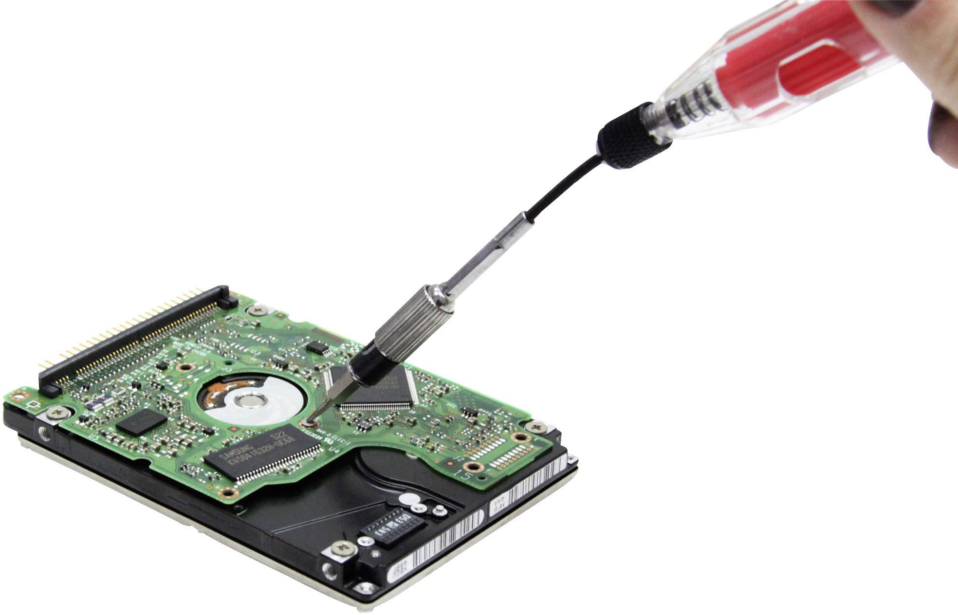 A hand holds a degausser over an exposed hard drive in order to erase the electronics or stored data.