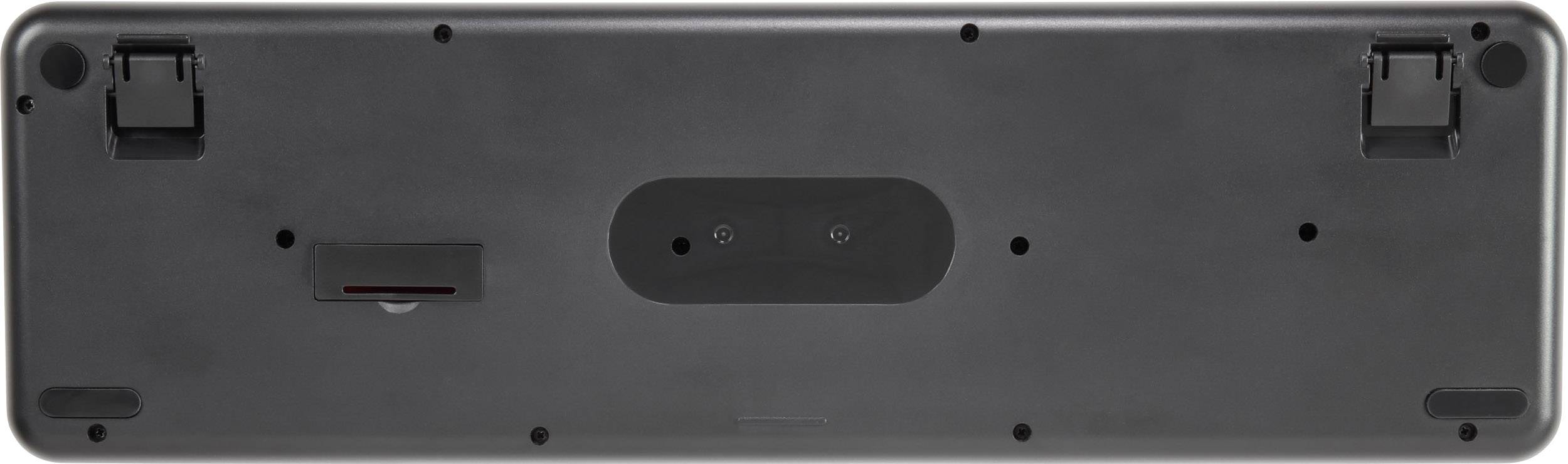 The underside of a black keyboard with folding feet and a battery compartment.