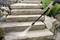 A person is cleaning stone steps outdoors with a pressure washer to remove dirt and deposits.