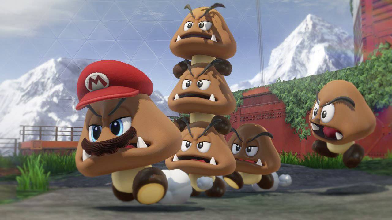 A group of Goombas, with a Goomba wearing a Mario cap at the front, stack themselves and run through a 3D landscape with mountains in the background.