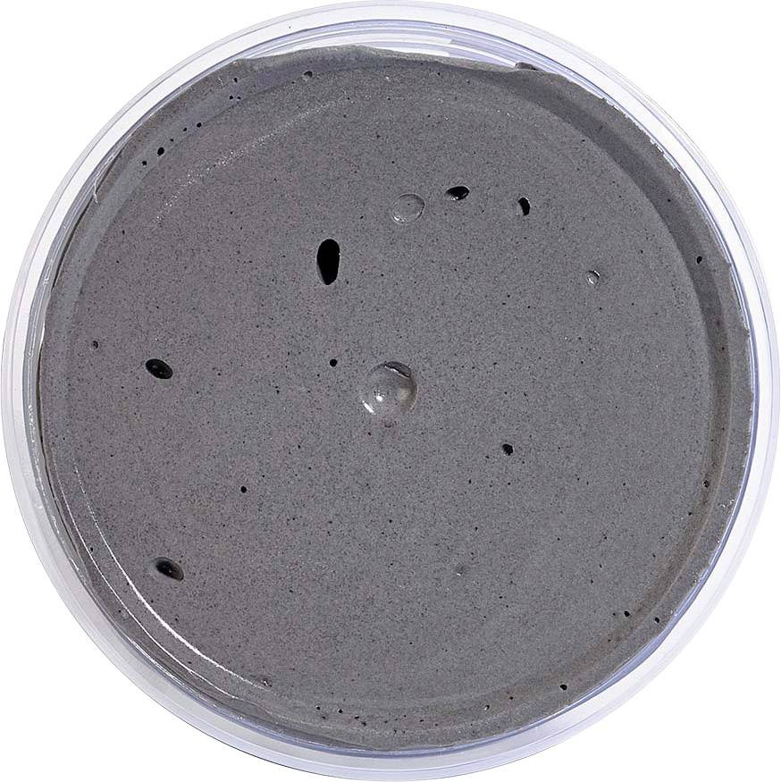 Dark, smooth paste in a round, transparent plastic container.