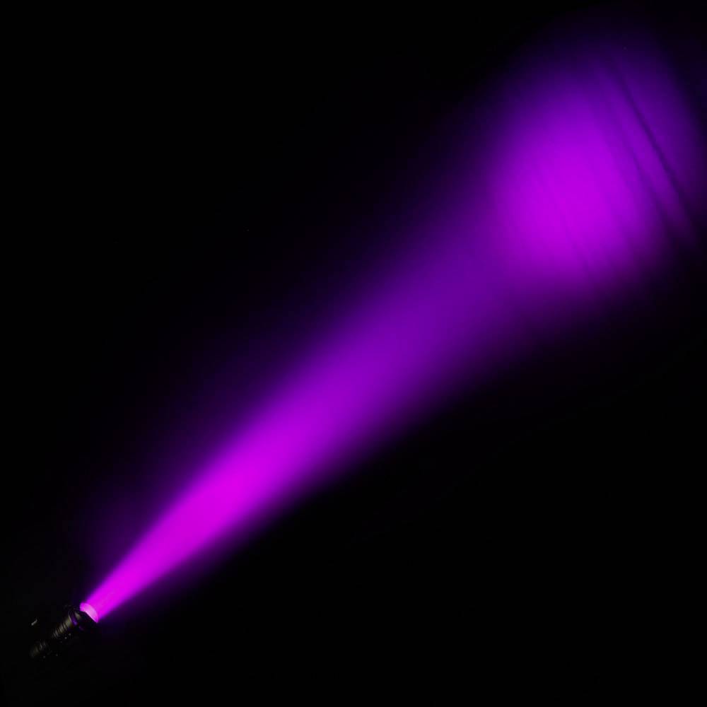 A violet light beam appears in the darkness, stretching from the bottom left corner to the top right.