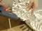 A person is using a hot glue gun to stick aluminium foil. Hands are holding the foil close to the glue gun.