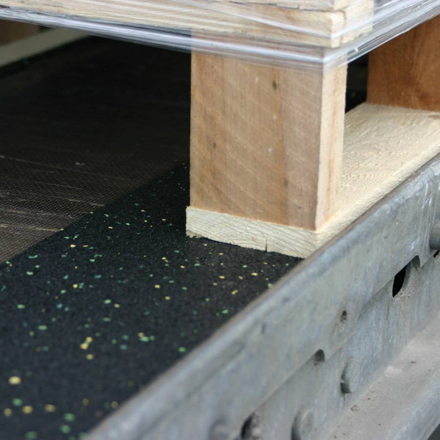 'Wooden pallet beneath a glass top on a structured metal base. Demonstrates craftsmanship and combination of materials.'