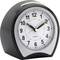 Black alarm clock with a dial. Hands pointing to 10:10. Buttons located on the top.