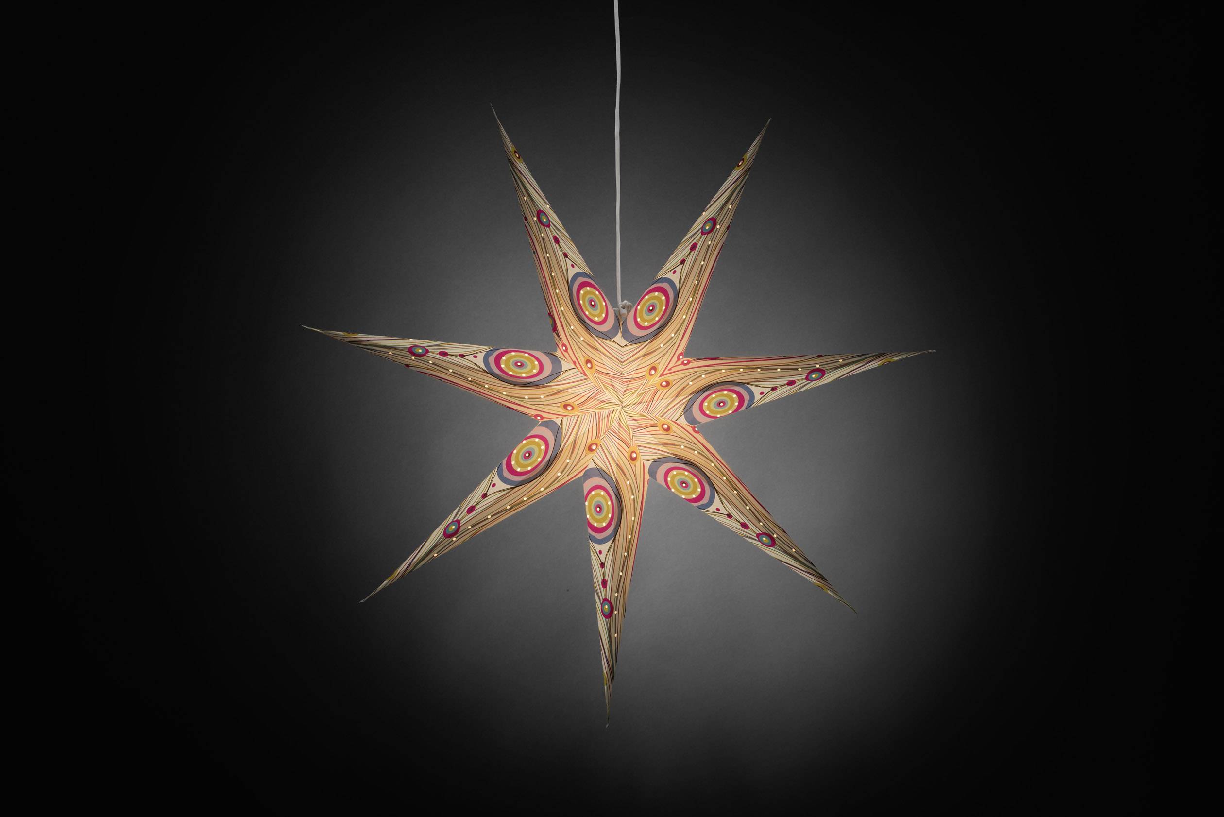 Decorative paper star lamp hung in a dimmed room with colourful patterns.