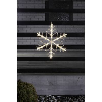 A luminous snowflake hangs before a wooden façade, surrounded by darkness. Christmas is in the air.