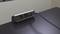 'A black cable is connected to a two-socket power strip on a table. The environment looks modern.'