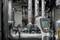A digital infrared thermometer displays -23.8°C and directs a red laser at pipes in an industrial plant room.
